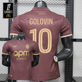 AS Monaco burgundy short-sleeve jersey shown from the front and back, with gold GOLOVIN 10 print, tonal pattern and APM Monaco sponsor, alongside a Ligue 1 graphic.
