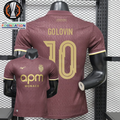 AS Monaco burgundy short-sleeve jersey, front and back views with gold GOLOVIN 10 print, tonal pattern and APM Monaco sponsor, alongside Europa League graphics.

