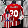 Front and back views of a red and white Atlético Madrid long-sleeve jersey with blue trim, white Giuliano number 20 print and Riyadh Air sponsor, alongside UCL graphics.
