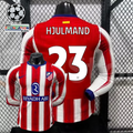 Front and back views of a red and white Atlético Madrid long-sleeve jersey with blue trim, white Hjulmand number 23 print and Riyadh Air sponsor, alongside UCL graphics.
