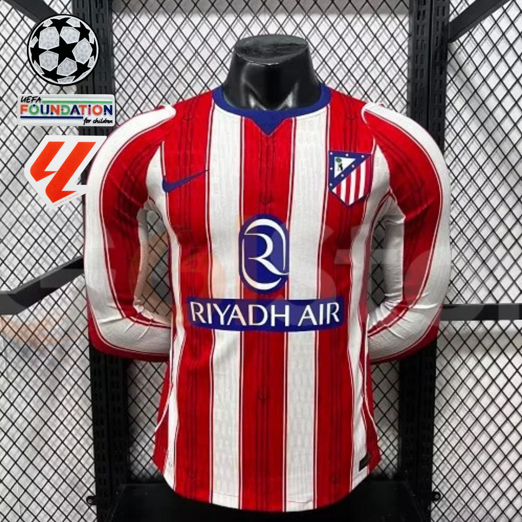 Front view of a red and white striped Atlético Madrid long-sleeve jersey with blue neckline details, club crest and Riyadh Air sponsor, alongside UCL and LaLiga graphics.