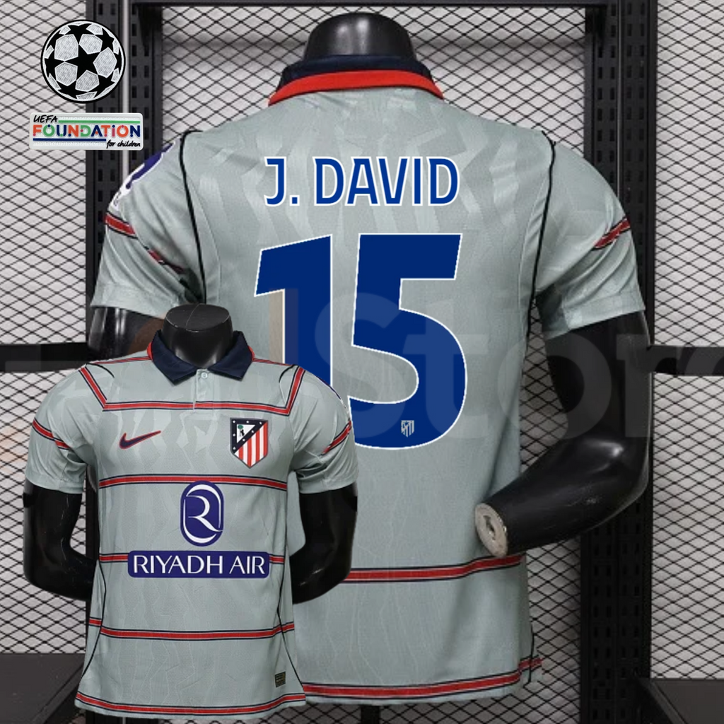 Front and back views of a light grey Atlético Madrid short-sleeve jersey with red horizontal stripes, blue J. David number 15 print and Riyadh Air sponsor, alongside UCL graphics.
