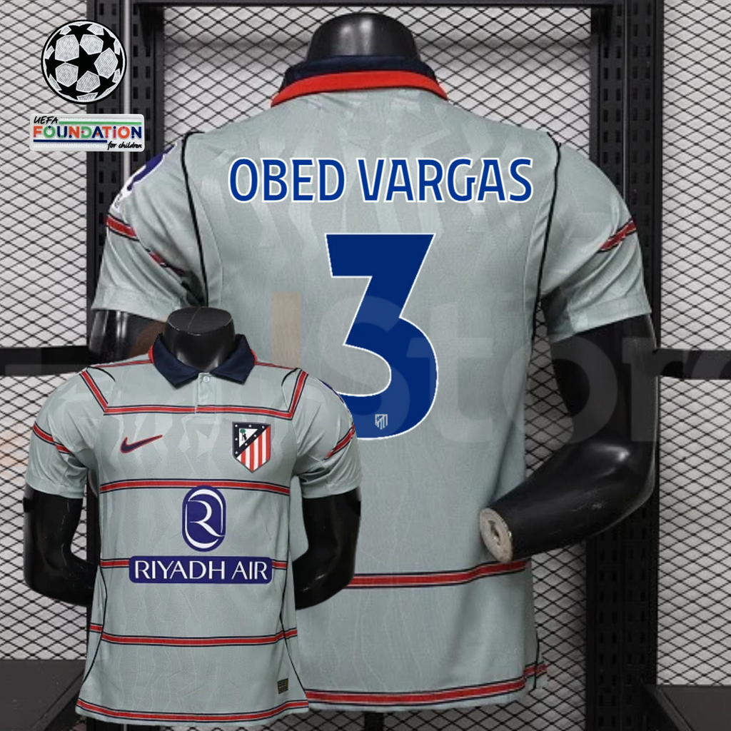 Front and back views of a light grey Atlético Madrid short-sleeve jersey with red horizontal stripes, blue Obed Vargas number 3 print and Riyadh Air sponsor, alongside UCL graphics.