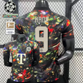 Front and back views of a black Bayern Munich short-sleeve jersey with a multicolored abstract design, cream Kane number 9 print and Telekom sponsor, alongside UCL and Bundesliga graphics.