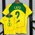Front and back views of a yellow Brazil retro short-sleeve home jersey with green trim, yellow Cafu lettering on a green upper back panel and green number 2 print.