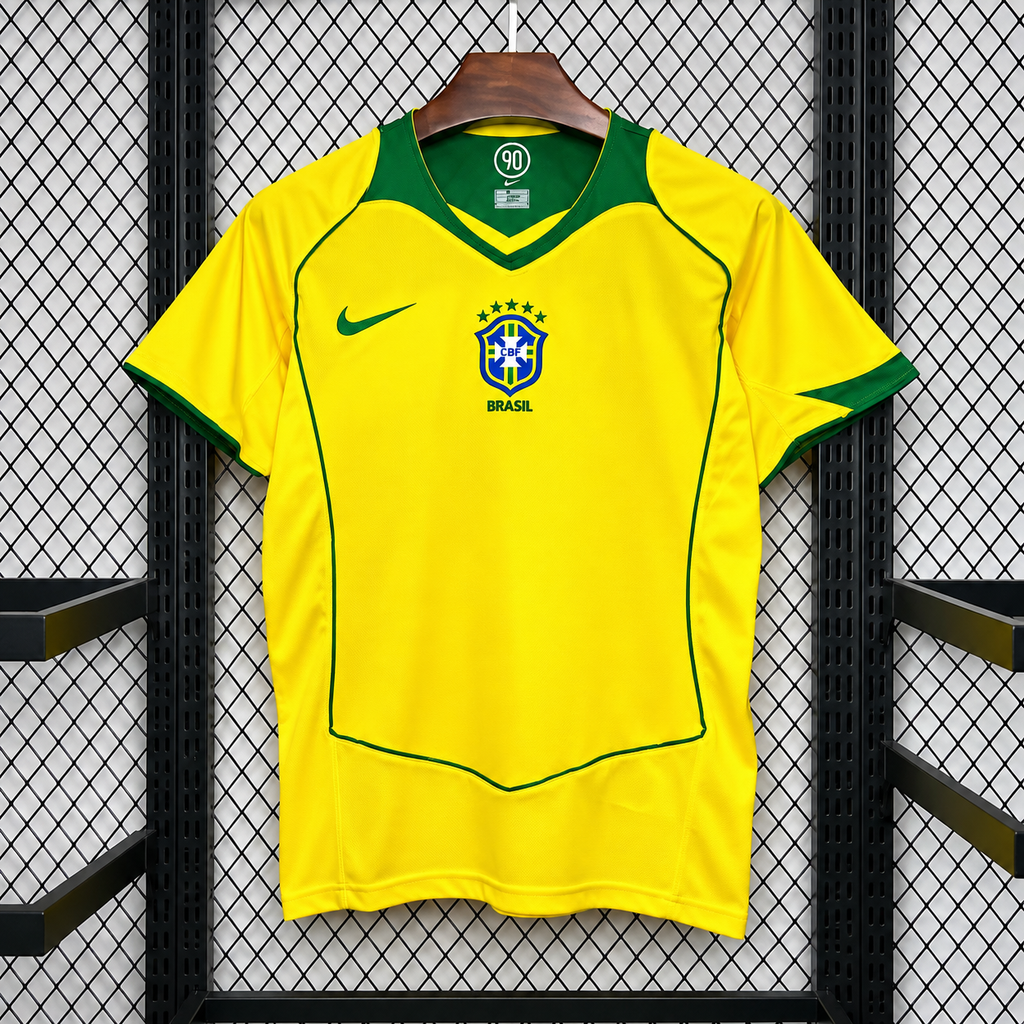 Front view of a yellow Brazil 2004 retro short-sleeve home jersey with a green V-neck, green sleeve trim and piping, and a central CBF crest.