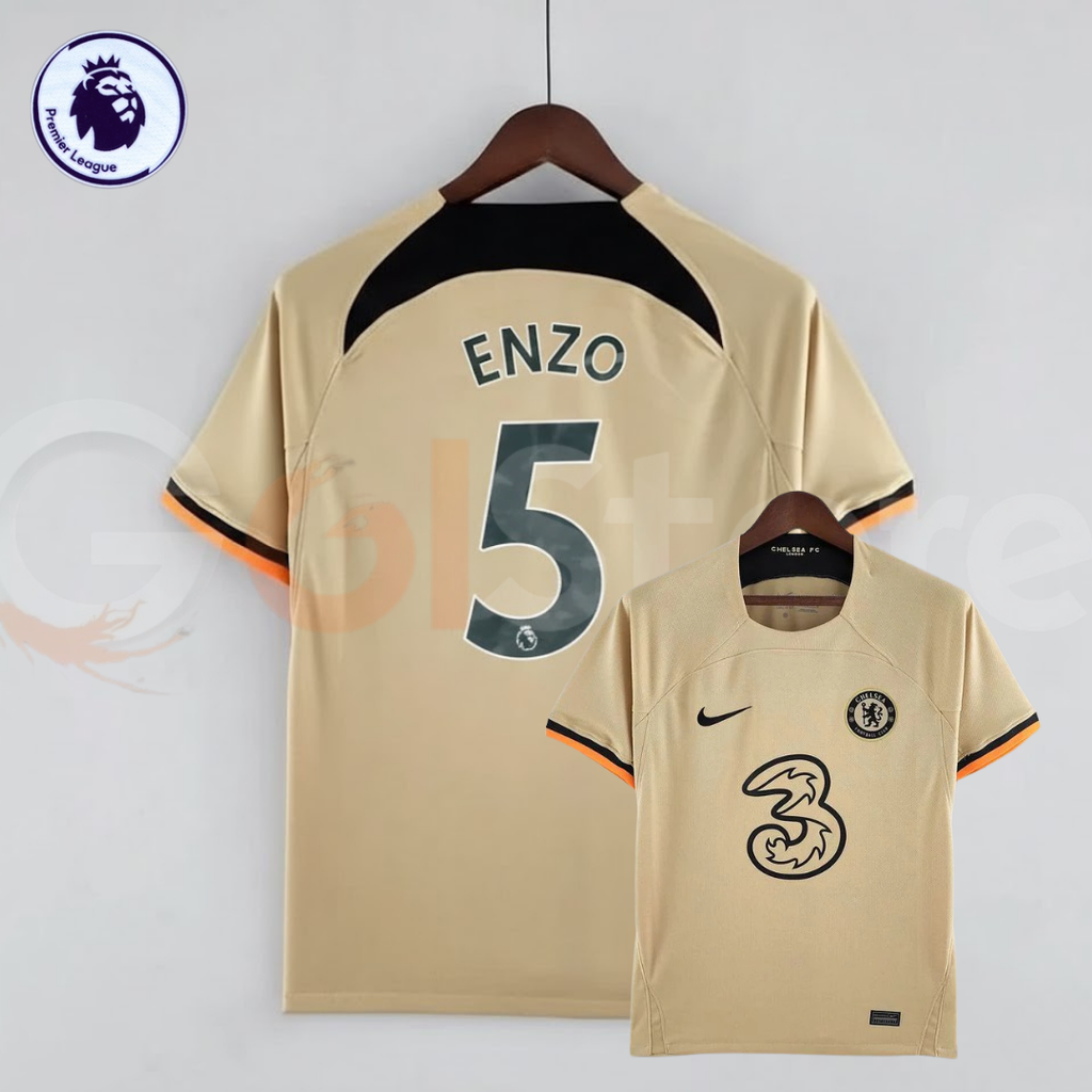 Front and back views of a pale gold Chelsea FC 2022–2023 short-sleeve third jersey with dark Enzo #5 printing, a black upper back panel and black and orange sleeve trim.