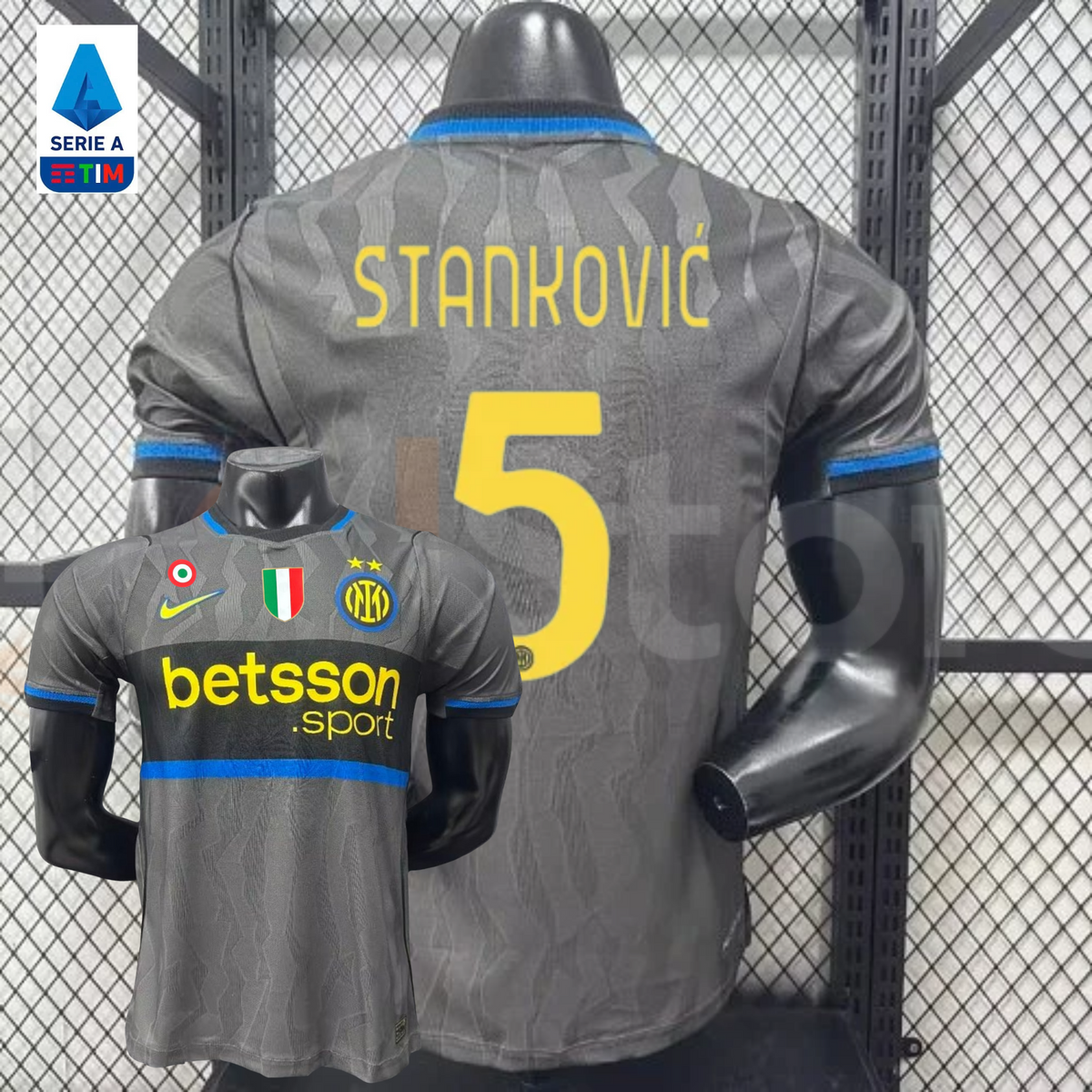 Front and back views of a grey Inter Milan short-sleeve third jersey with blue trim, yellow Stanković number 5 print and Betsson Sport sponsor, alongside a Serie A badge graphic.