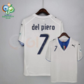 Front and back views of a white Italy short-sleeve retro away jersey with a blue neckline panel, dark Del Piero number 7 print and sleeve patches, alongside a Germany 2006 World Cup graphic.