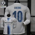  Front and back views of a white Manchester City long-sleeve jersey with blue central stripes, blue Cherki number 10 print and Etihad Airways sponsor, alongside UCL graphics.