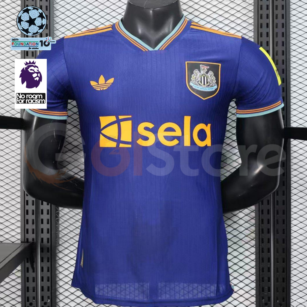 Front view of a blue Newcastle United short-sleeve third jersey with gold Sela sponsor and shoulder stripes, light blue trim, and UCL and Premier League badge graphics alongside.