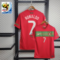 Front and back views of a red Portugal 2010 retro short-sleeve home jersey with a green chest band, Ronaldo number 7 print and World Cup sleeve patch.