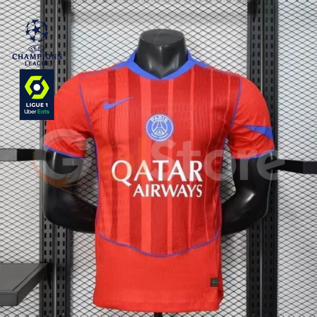 Front view of a red PSG short-sleeve jersey with tonal vertical stripes, blue trim, a central club crest and Qatar Airways sponsor, alongside UCL and Ligue 1 graphics.