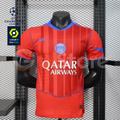 Front view of a red PSG short-sleeve jersey with tonal vertical stripes, blue trim, a central club crest and Qatar Airways sponsor, alongside UCL and Ligue 1 graphics.