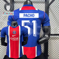 Front and back views of a blue PSG short-sleeve jersey with a red and white central stripe, Pacho lettering and white number 51, alongside trophy and UEFA Foundation graphics.