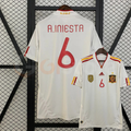 Spain white short-sleeve retro jersey shown from the front and back, with red A. INIESTA 6 print, red and yellow shoulder stripes and a gold FIFA World Champions chest badge.
